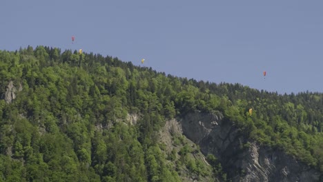 paragliders in front of a hill