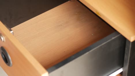 man's hand open drawer wooden and pick a smart phone