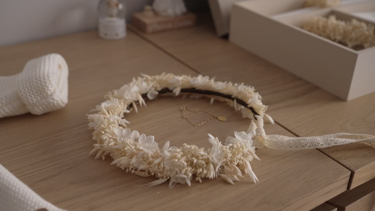 handmade floral headpiece with soft textures and lace ribbon placed in warm light