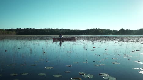 un hombre pescando pacíficamente en su canoa en plum lake en minneola, fl
