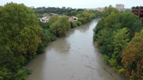 Flooded-river-le-Lez-with-trees-along-in-Montpellier-aerial-shot-France