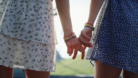 Handheld-video-of-two-unrecognizable-women-standing-and-holding-hands