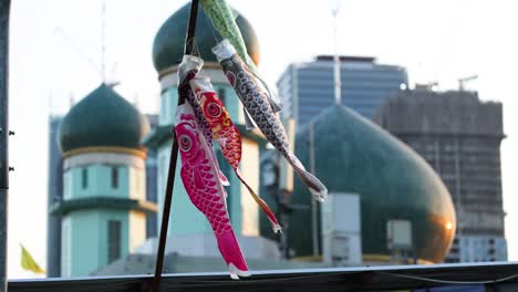 colorful carp streamers flying against urban backdrop