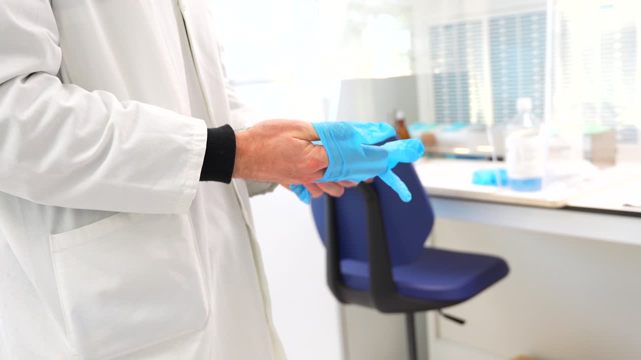 Scientist putting on gloves in a lab