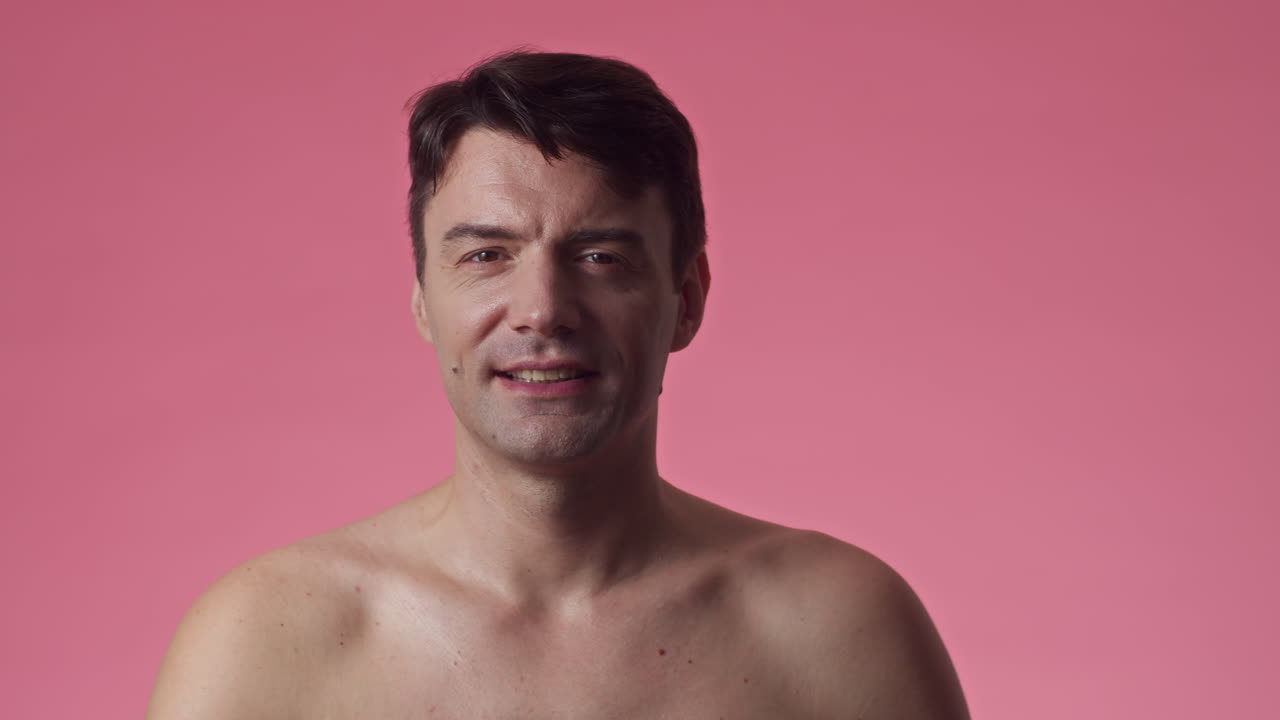 Male Millennial Looking at Camera in Pink Background
