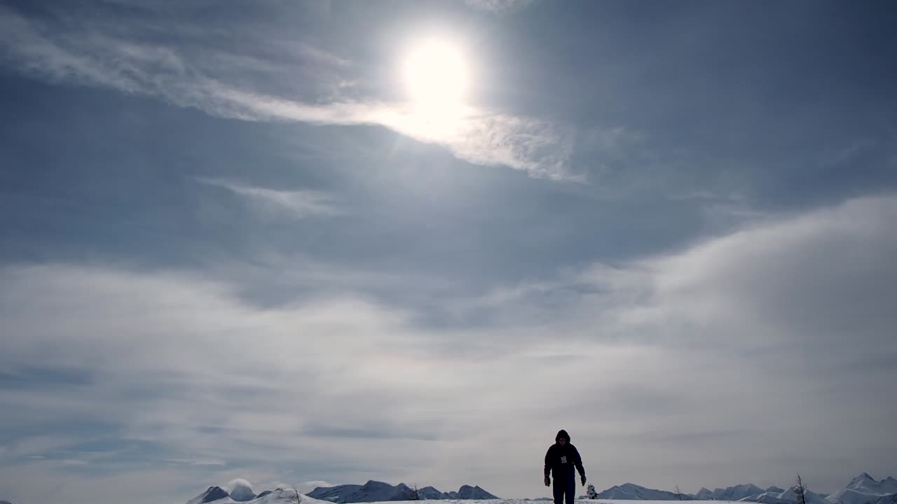 산 꼭대기에 눈 속에서 걷는 남자