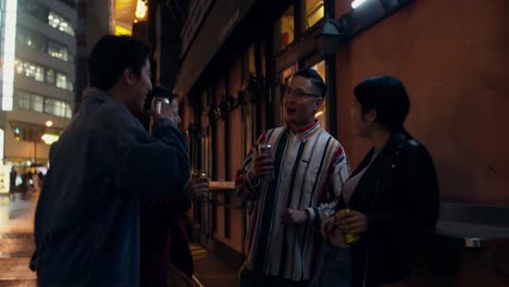 friends enjoying drinks in a city street at night