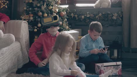 sweet children play with christmas presents on wooden floor