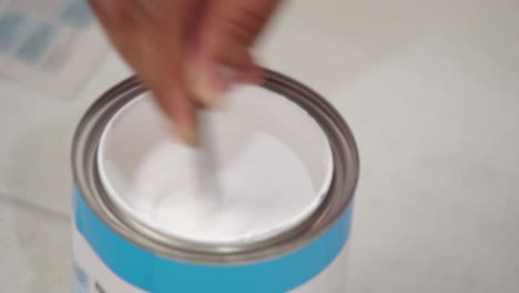 cerca de la mano del pintor mezclando pintura blanca