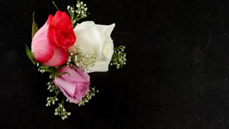 Bouquet-of-red,-white-and-pink-roses-on-black-surface-4k