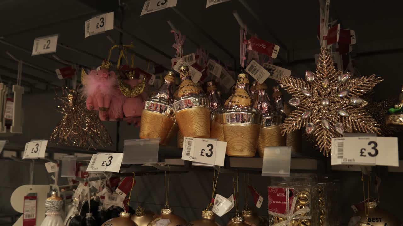 Festive retail multi coloured glittering Christmas ornaments hanging for sale in department store