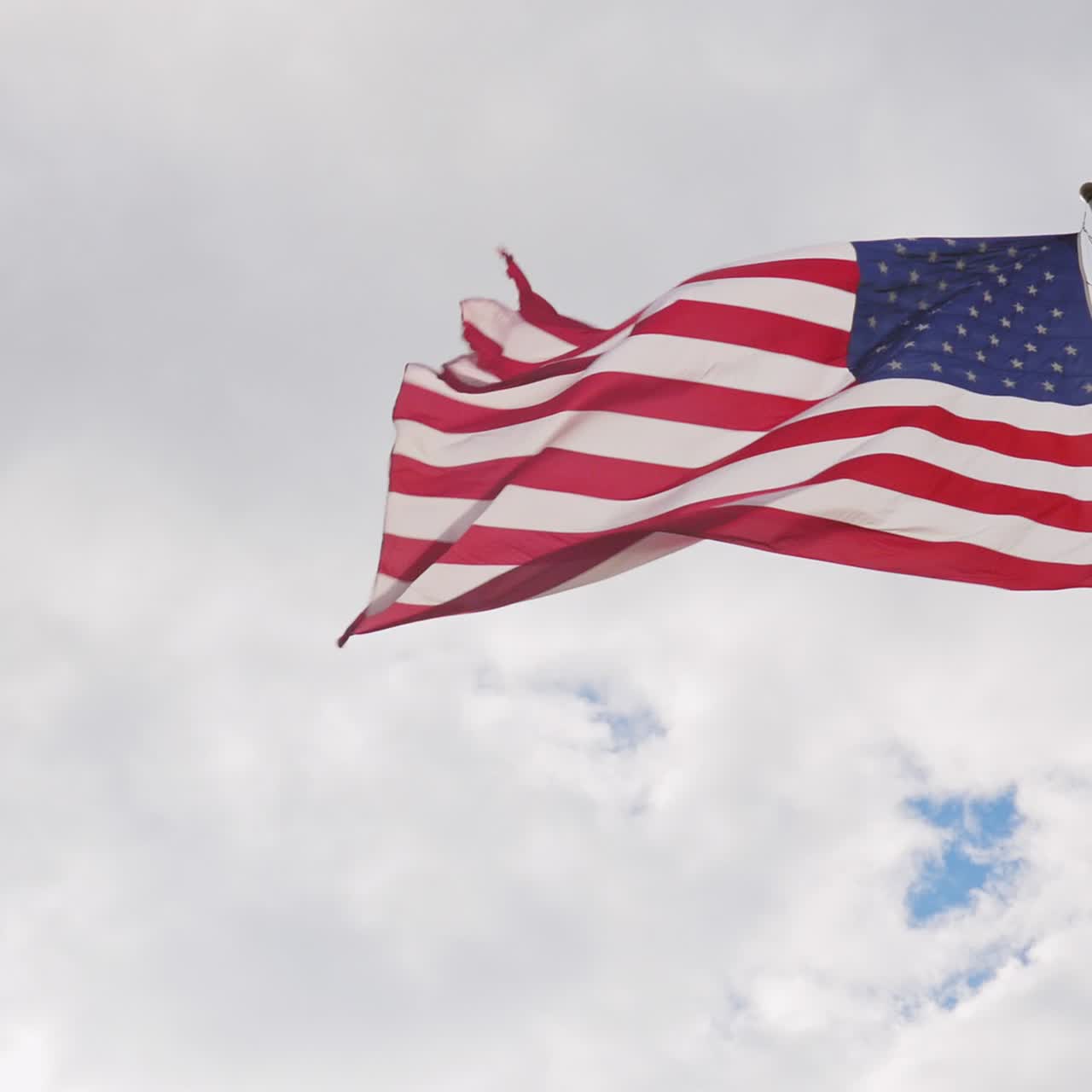 gran bandera estadounidense sobre un fondo de cielo gris bellamente iluminado por el sol 1