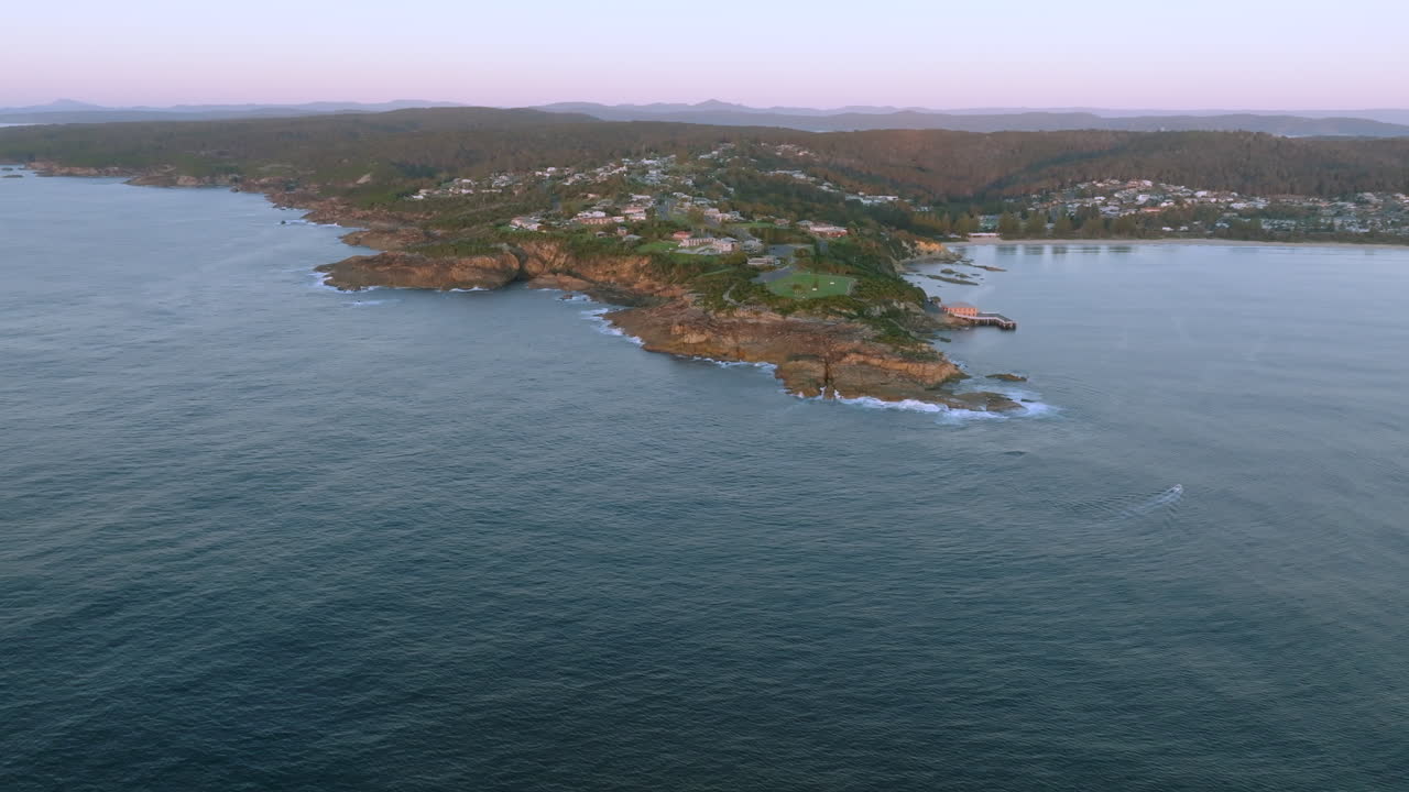 Aerial: Wide drone shot of Tathra and the surrounding landscape on the South Coast, NSW, Australia