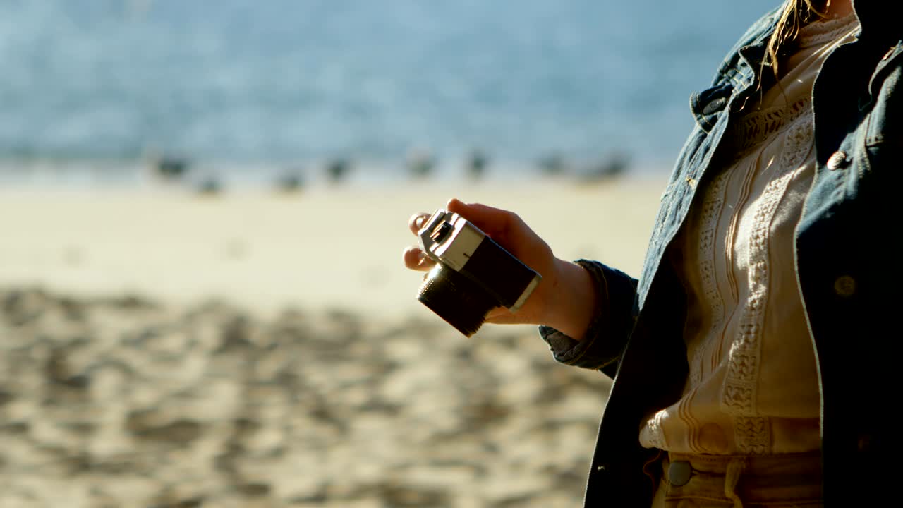 해변 4k에서 카메라로 사진을 찍는 여자