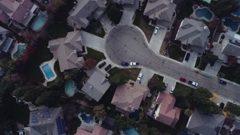 drone shot looking down on a suburban neighborhood with houses, trees, and streets. 4k.