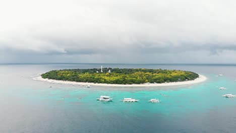 aerial footage of balicasag island in philippines. stunning view on coral reef and circle island. panglao, bohol, white beach, palm trees, boats / 4k drone video