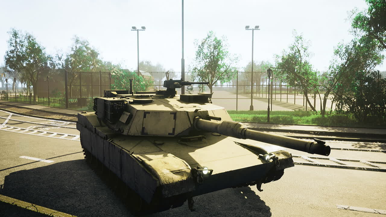 Militær tanks parkert på en stille vei nær en sportsbane på dagtid