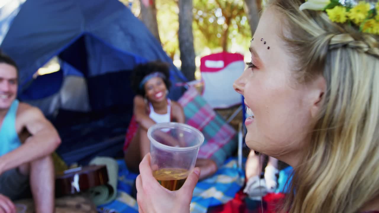 mujer tomando un vaso de cerveza con amigos en el parque 4k