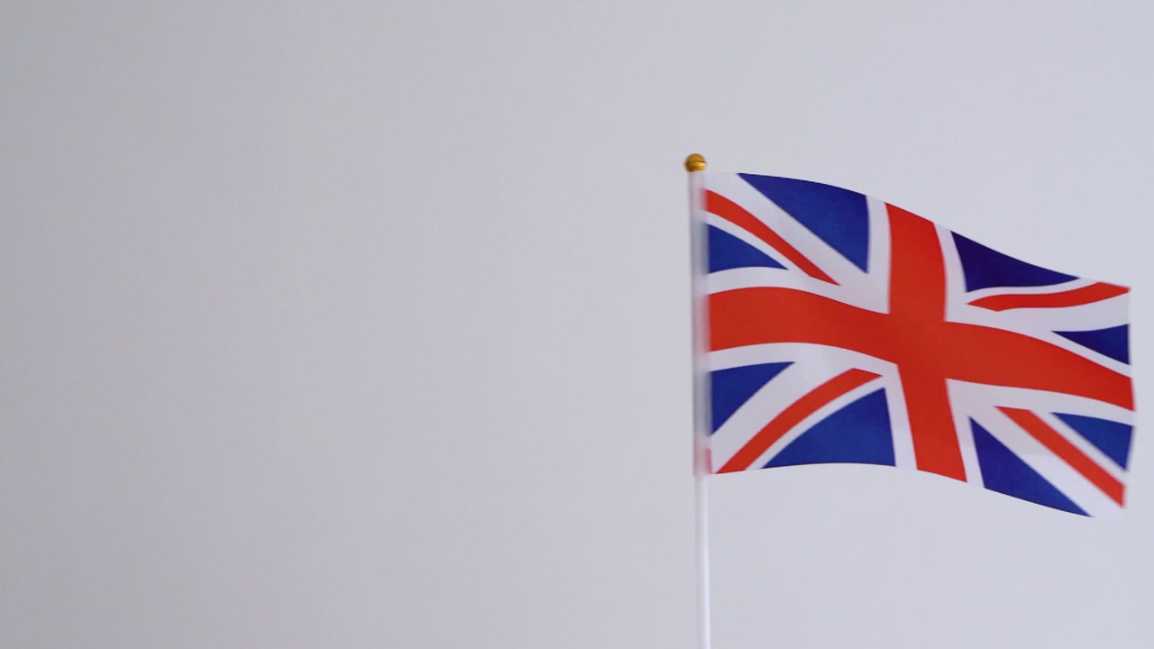 United Kingdom flag waving on white background. British flag in slow motion.