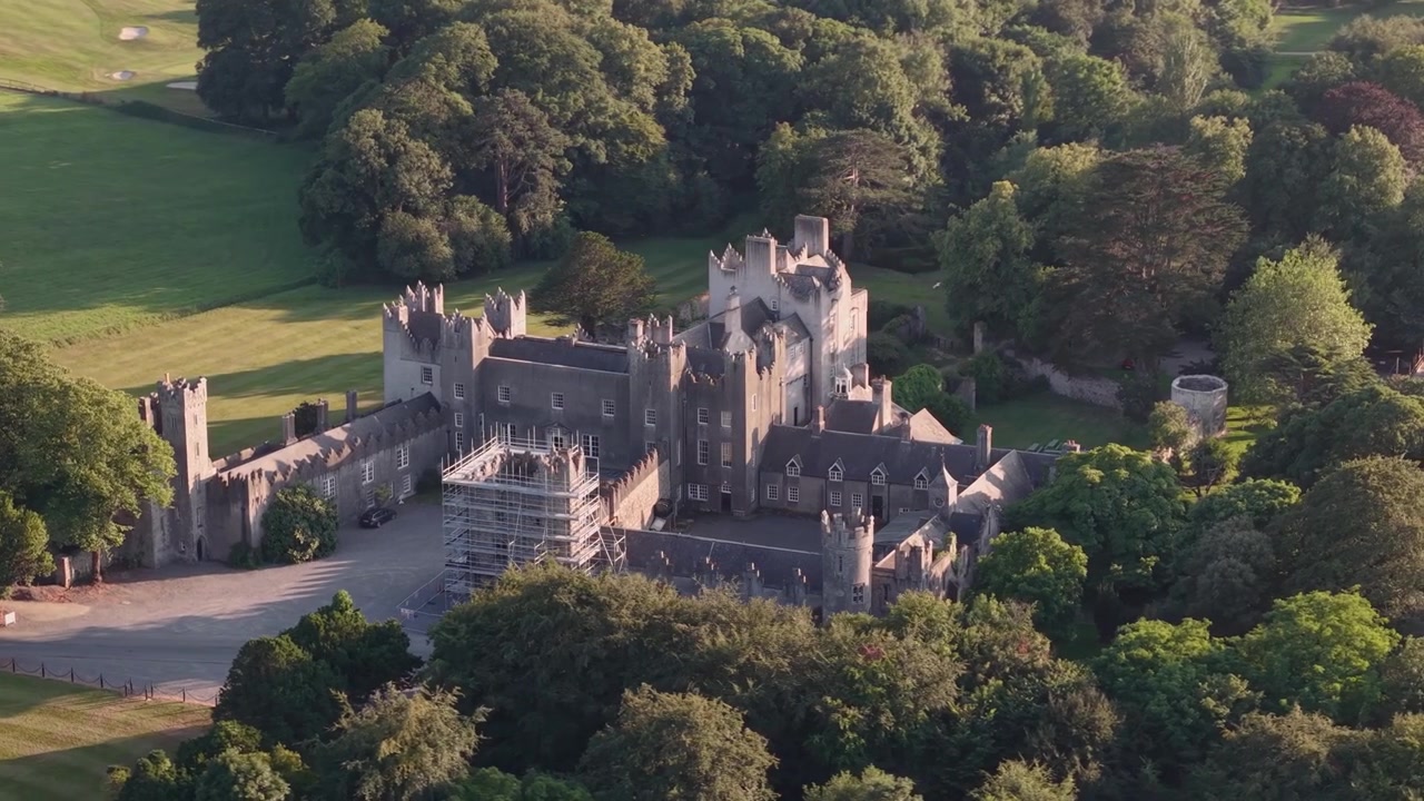 Gros plan aérien au coucher de soleil doré sur le château historique de Howth et son parc environnant, comté de Dublin.