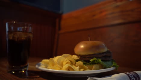 Hamburger-Mit-Kartoffelchips-Am-Tisch-Im-Restaurant