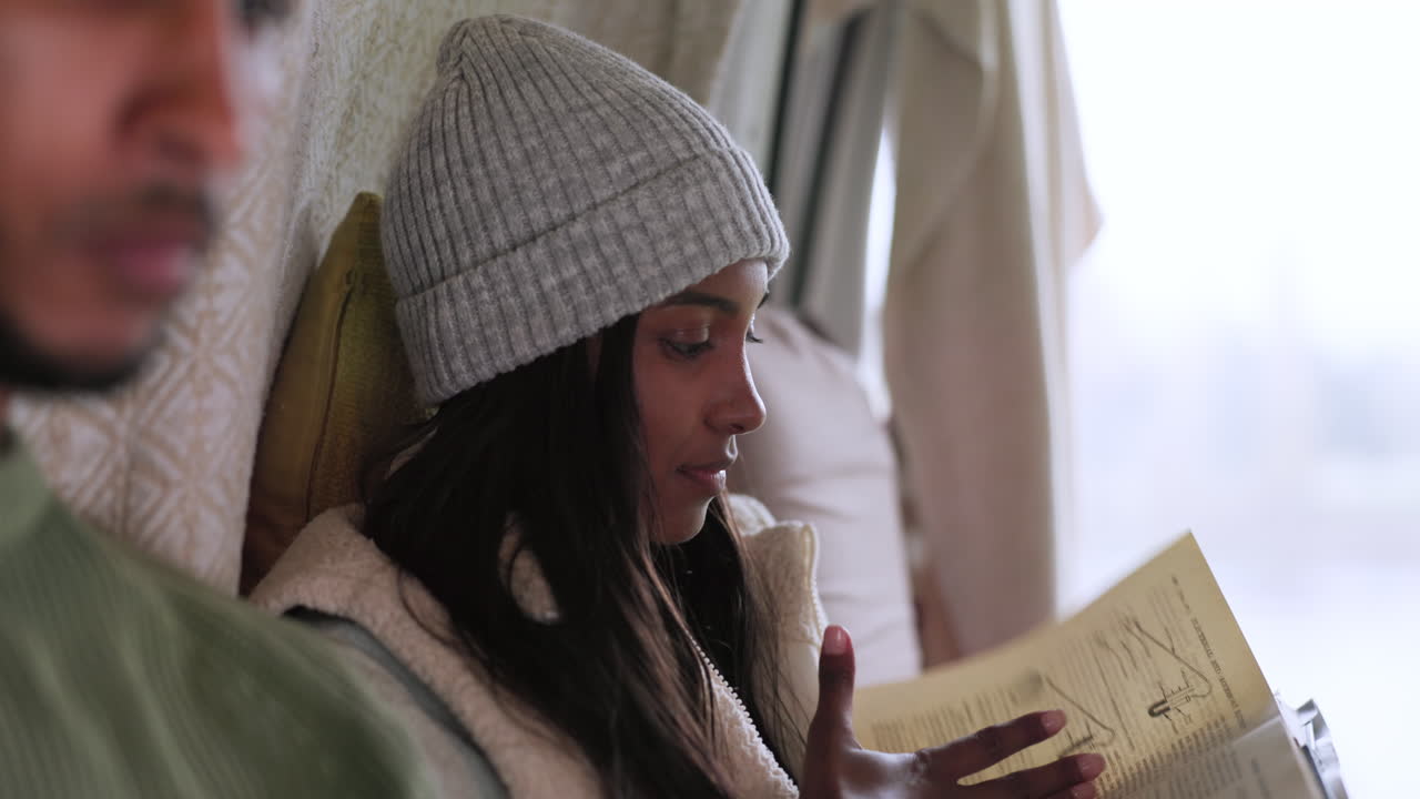 Woman reading a book while on an outdoor camp
