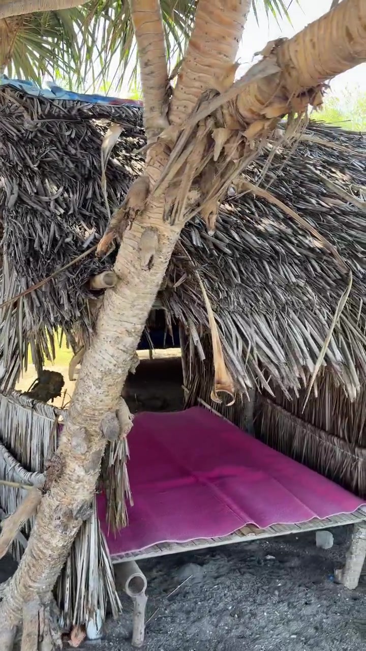 Capanne Tradizionali di Bambù con Tetto di Paglia su una Spiaggia Tropicale