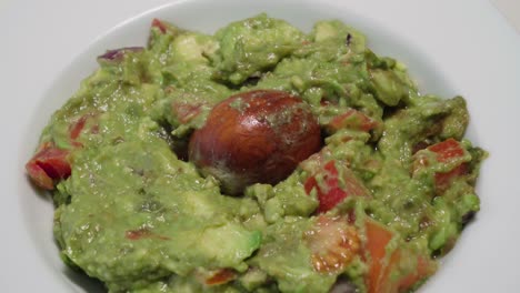 Kippen-Sie-Nach-Unten,-Schüssel-Mit-Frischer-Guacamole-Mit-Avocadokern,-Nahaufnahme