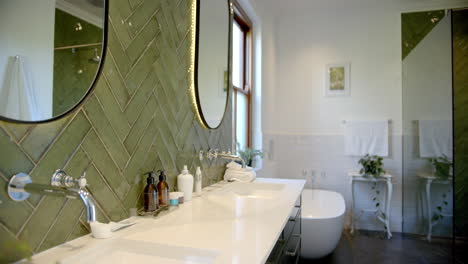 beautiful mirrors, taps, sinks and green walls in sunny bathroom