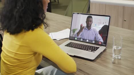 mujer de negocios afroamericana usando una computadora portátil para una videollamada con un colega de negocios afroamericano