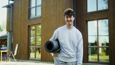 man with yoga mat and water bottle outside