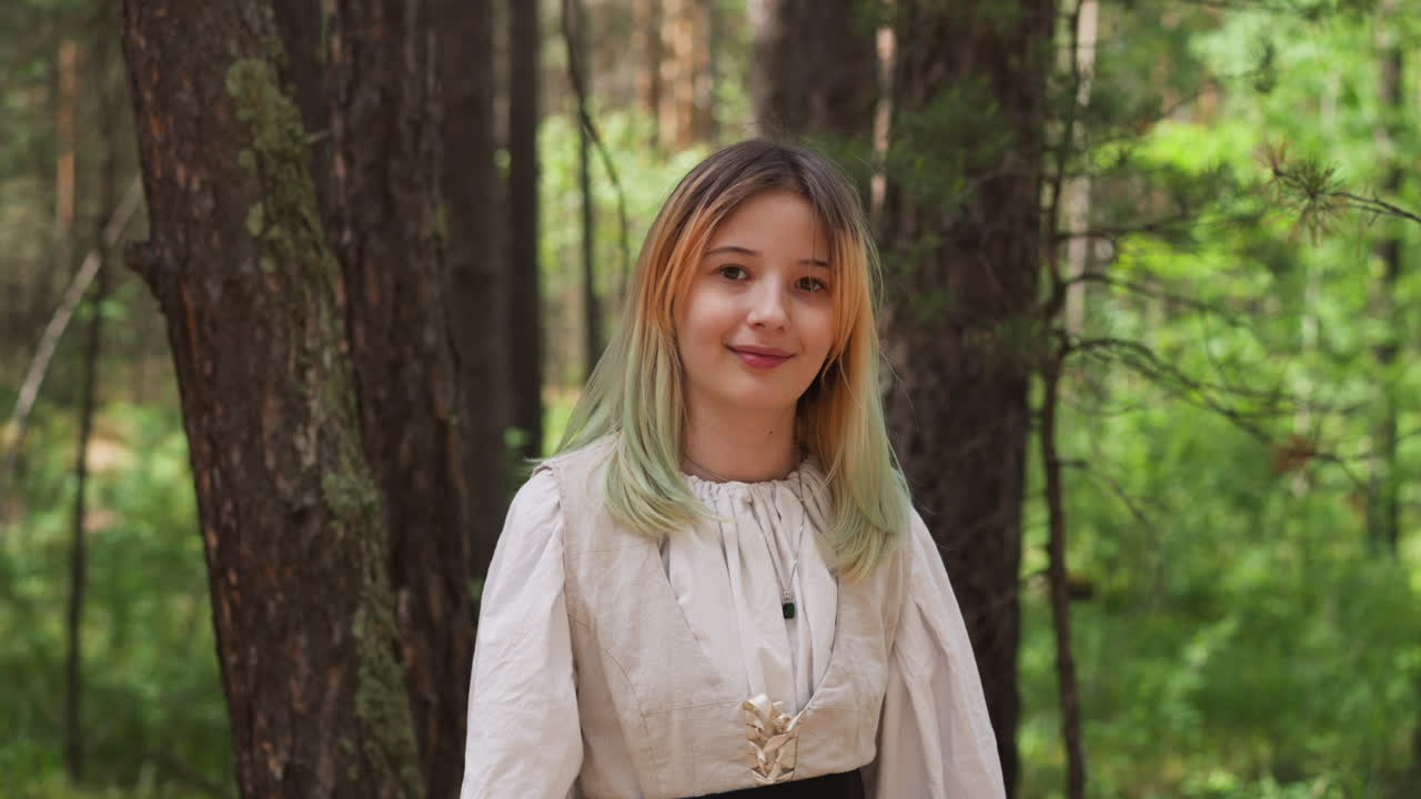 Gadis berambut pirang tersenyum di hutan abad pertengahan.