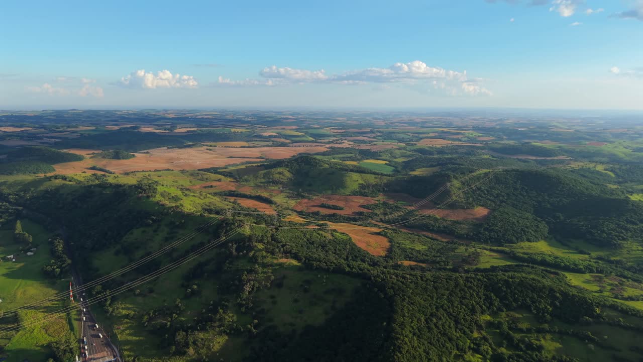 Mosaico agricolo di pascoli, campi coltivati e frammenti di foresta si estende su un terreno ondulato lungo la BR-277 vicino a Laranjeiras do Sul, Paraná, Brasile meridionale, all'interno della geografia dell'Altopiano Atlantico, aerea.