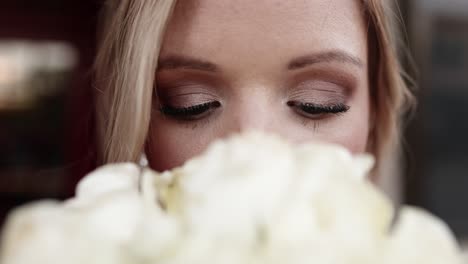 close up shot of the bride’s eyes with her white rose bouquet in the foreground