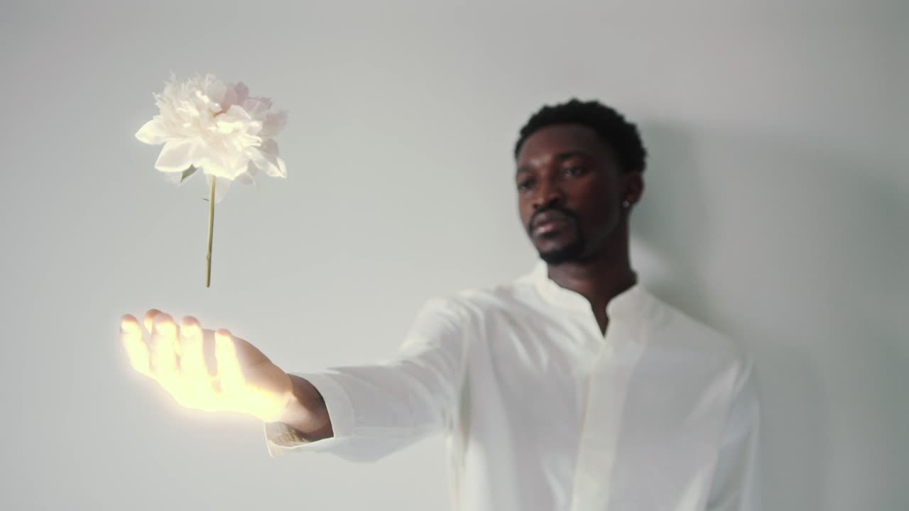 Young Man Holding Arm Outstretched and Performing Flower Levitation