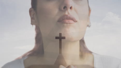 cross symbol animation over close-up of woman with clasped hands