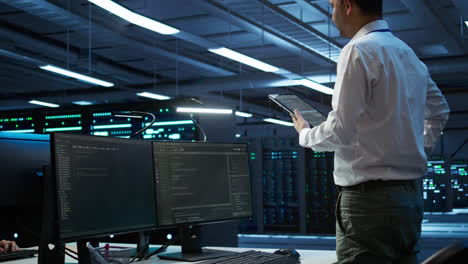 it professional doing maintenance on server room infrastructure using tablet