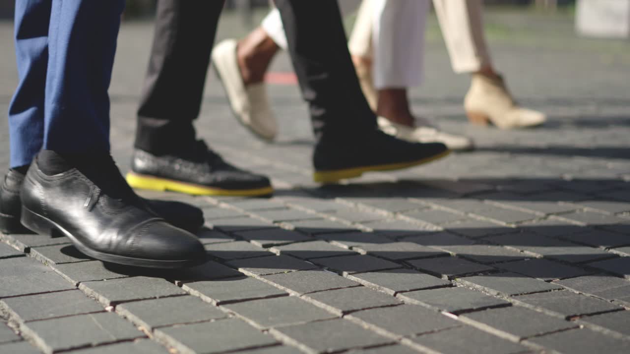 Legs of business people walking along the street