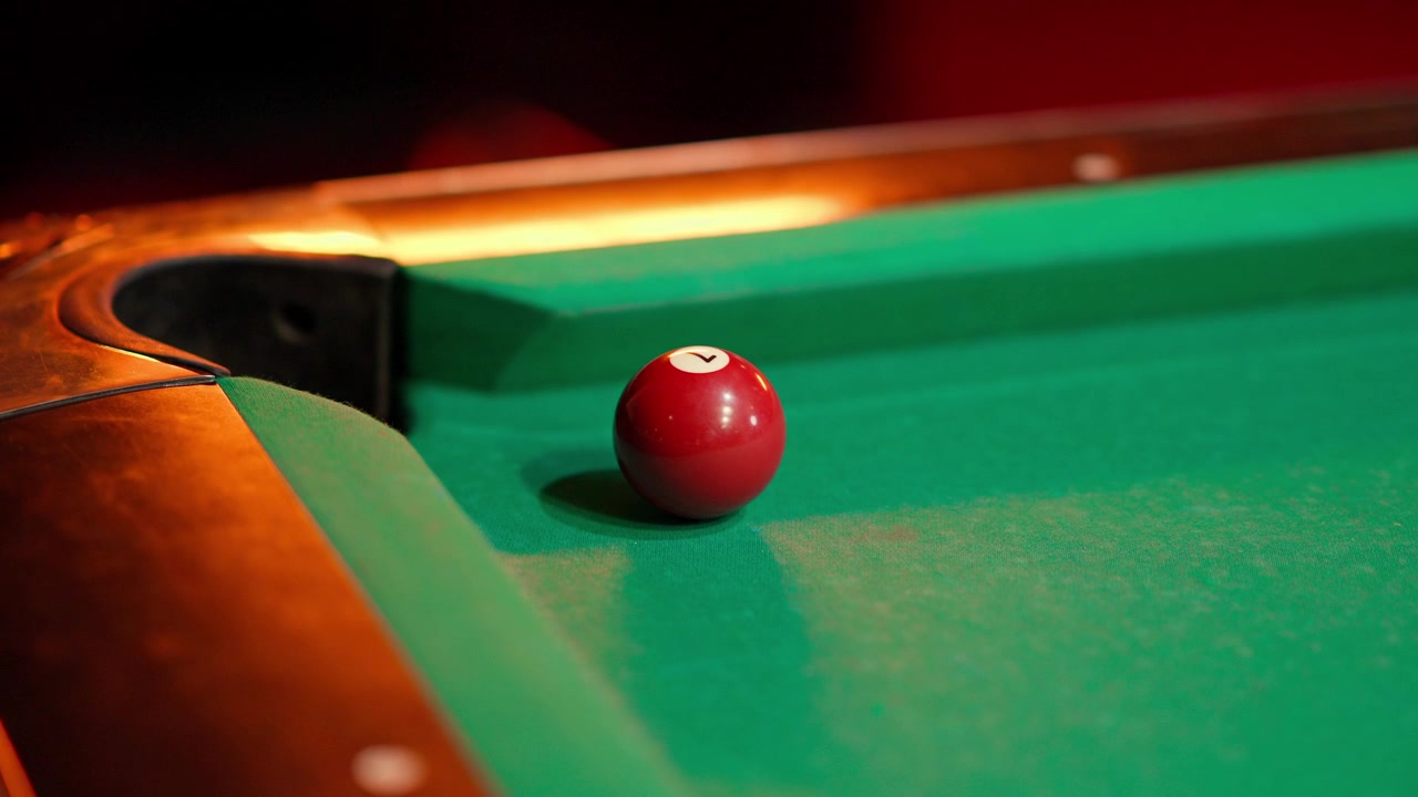 Red Number 7 Billiard Ball Sinks into Pocket on Green Table