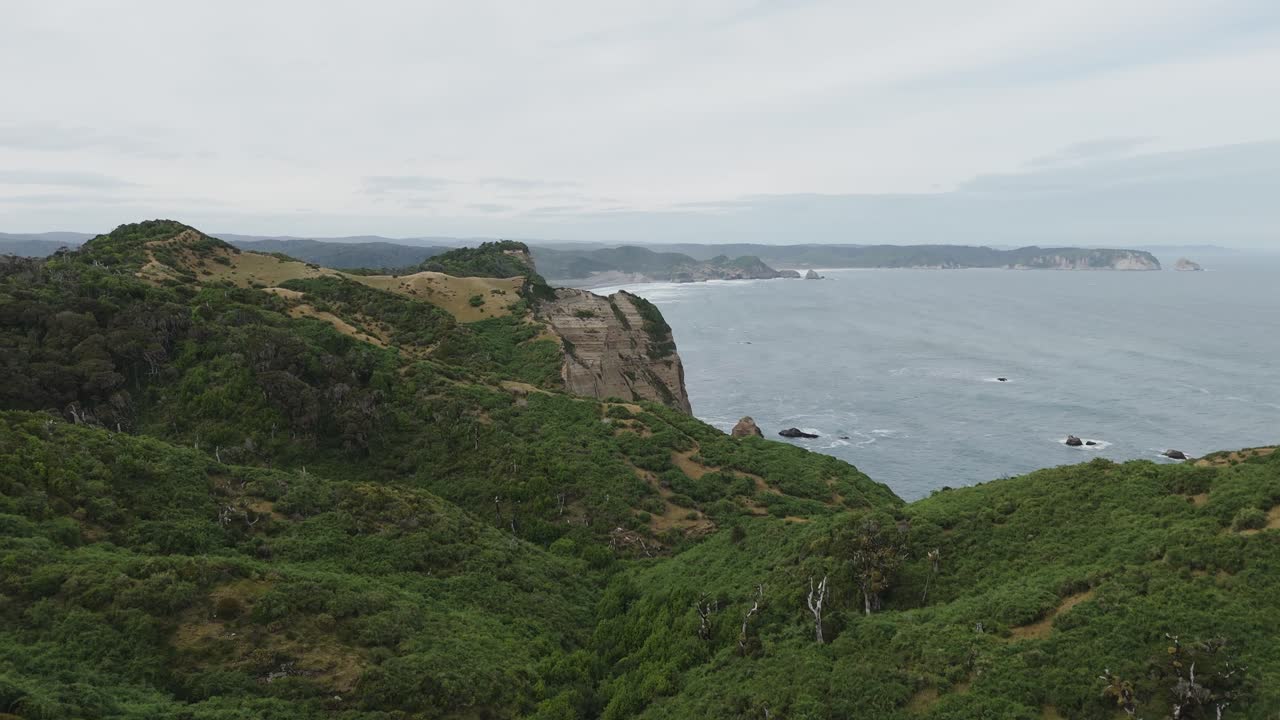 Aerial view capturing dramatic cliffs and coastline near Muelle De Las Almas, highlighting Chiloe Island's natural beauty