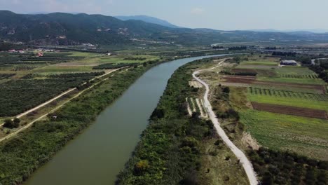 Vista-Aérea-Sobre-El-Río-Que-Atraviesa-Los-Campos-En-El-Campo,-Río-Strimonas,-Grecia