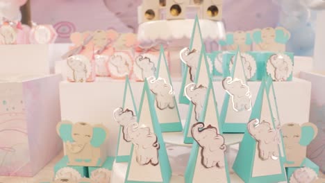 gender reveal candy table with pink and blue candy boxes and elephant theme