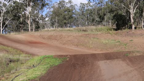 dirt bike riders racing on a rural track