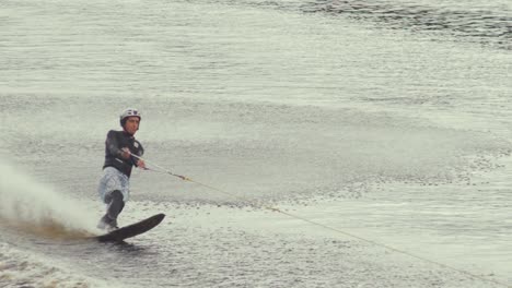 Young-man-slalom-skis-behind-speed-boat