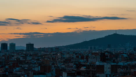 Time-lapse-of-a-golden-sunset-behind-Barcelona,-Spain-on-a-warm-summer-night