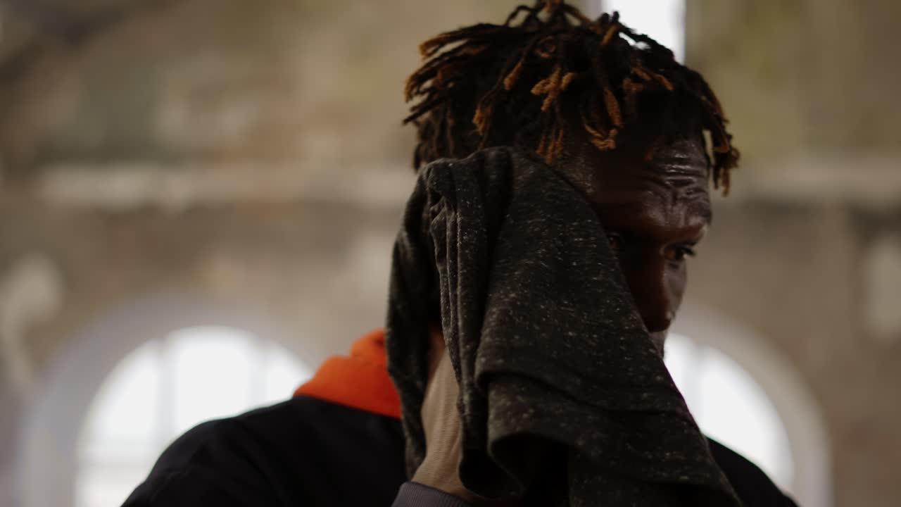 피곤 한 아프리카계 미국인 운동 선수 는 훈련 후 얼굴 에  ⁇  을  ⁇ 는다