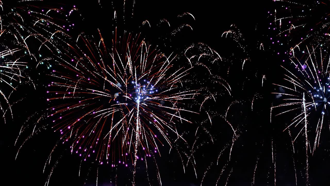 coloridos fuegos artificiales explotando en el cielo nocturno. celebraciones y eventos en colores brillantes.