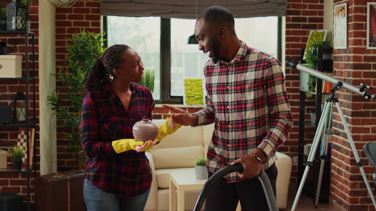 Young life partners doing household chores and cleaning apartment