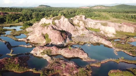 vista aérea cantera con agua azul rodeada de gran roca