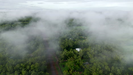 dron aéreo de zarcillos brumosos de niebla de nubes sobre propiedades rurales y carreteras de tierra